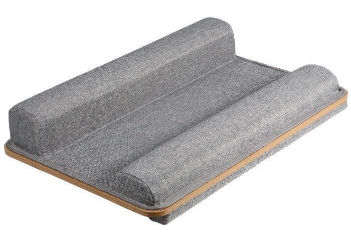 Grijze stoffen laptopstandaard met houten basis en twee afgeronde kussens, schuin van boven in driekwartaanzicht gefotografeerd