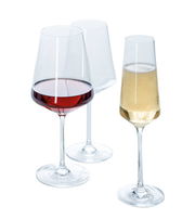 Drei elegante Kelchgläser aus der Puccini-Serie, gefüllt mit Rotwein, Weißwein und Sekt, aus einer leicht seitlichen Perspektive fotografiert.