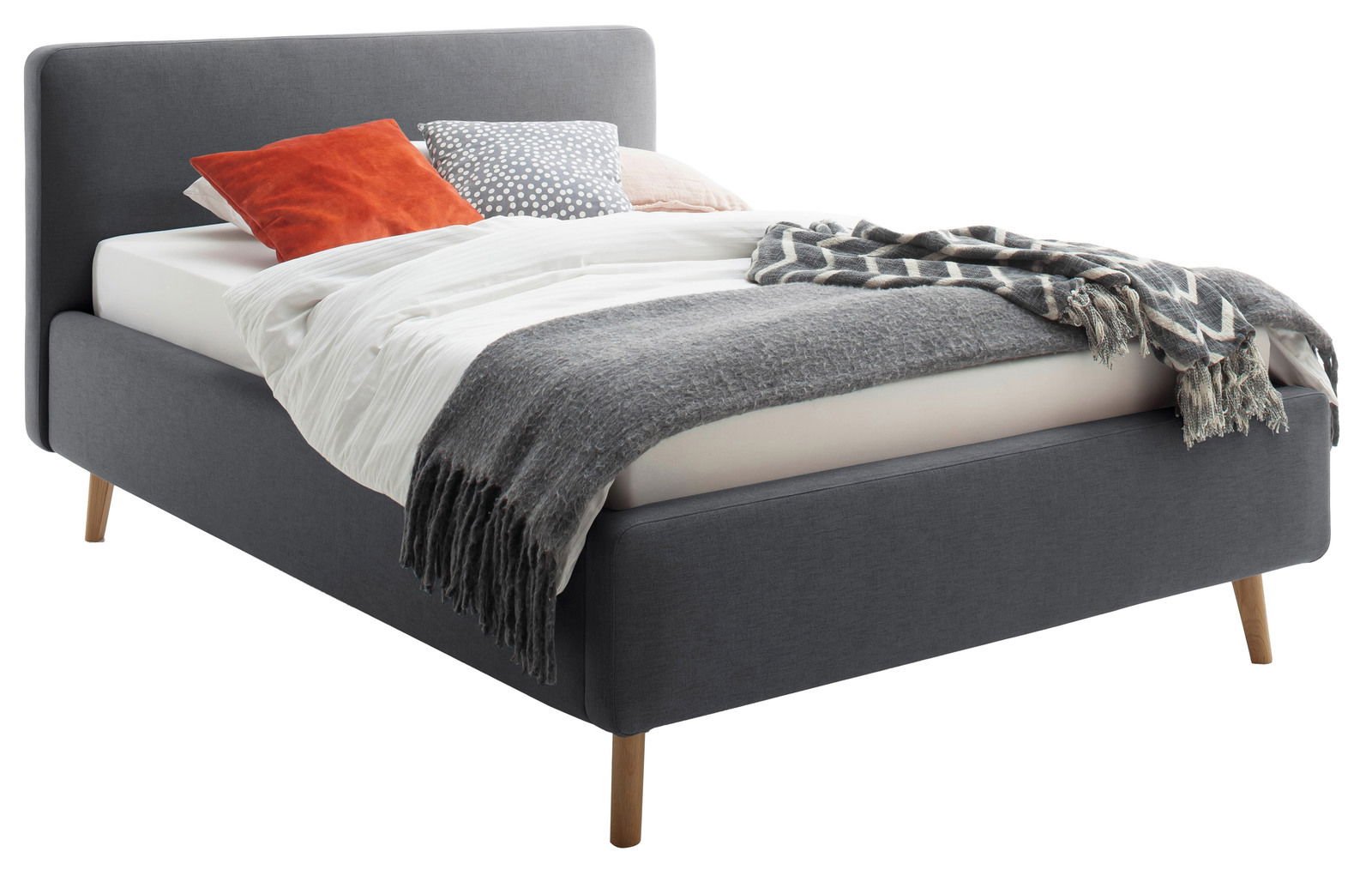 Polsterbett in Grau mit Holzfüßen, dekoriert mit Kissen und Decken, seitliche Perspektive