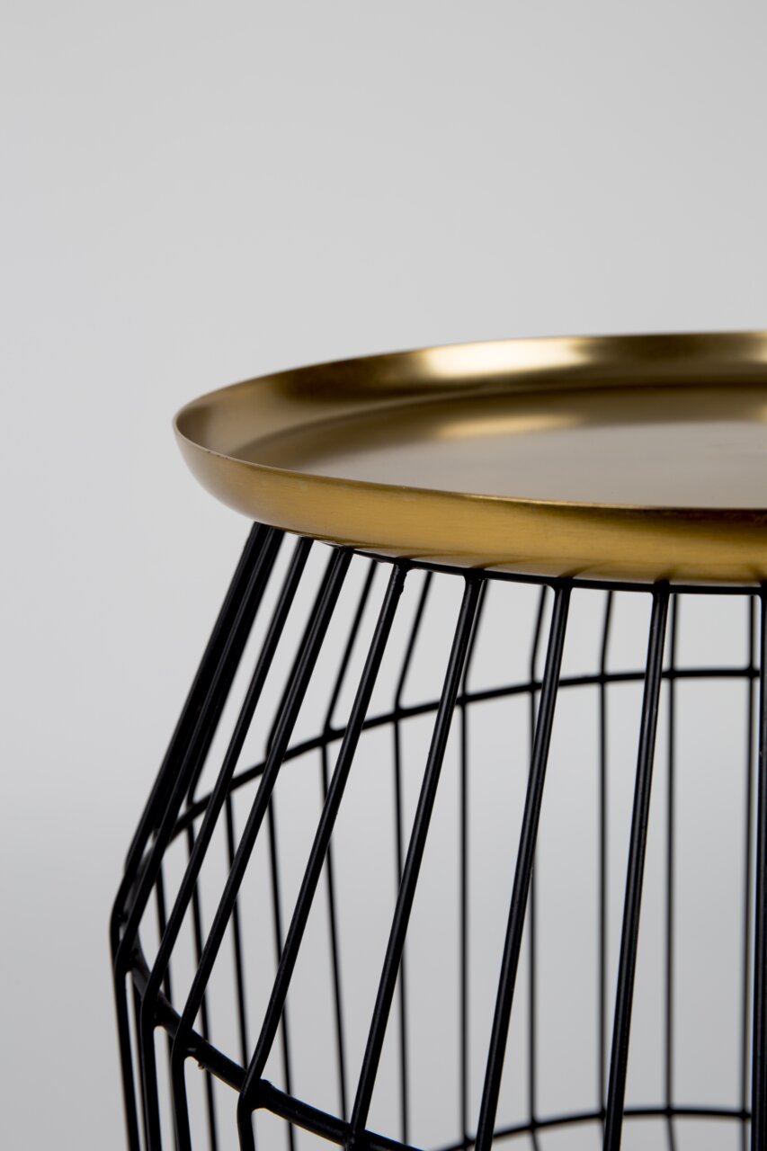 Close-up van een bijzettafeltje met een zwart draadframe en een gouden tafelblad, gezien vanaf de zijkant