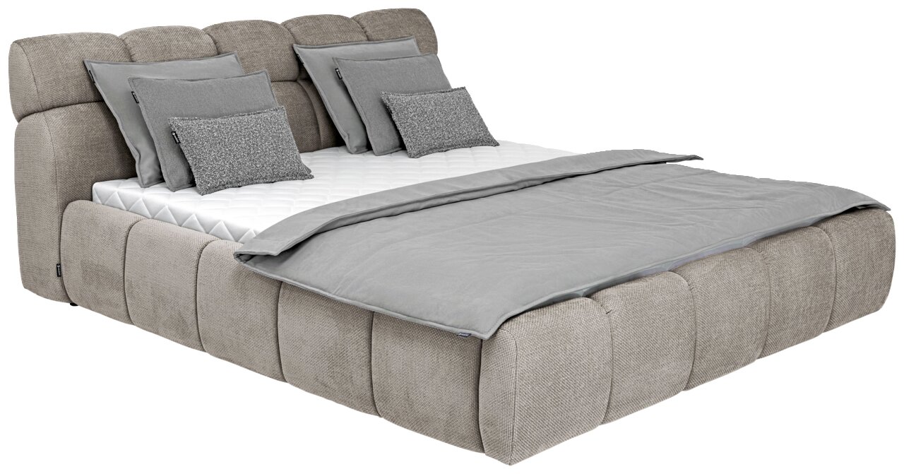 Polsterbett in seitlicher Perspektive mit grauem Stoffbezug, mehreren Kissen und einer grauen Decke.