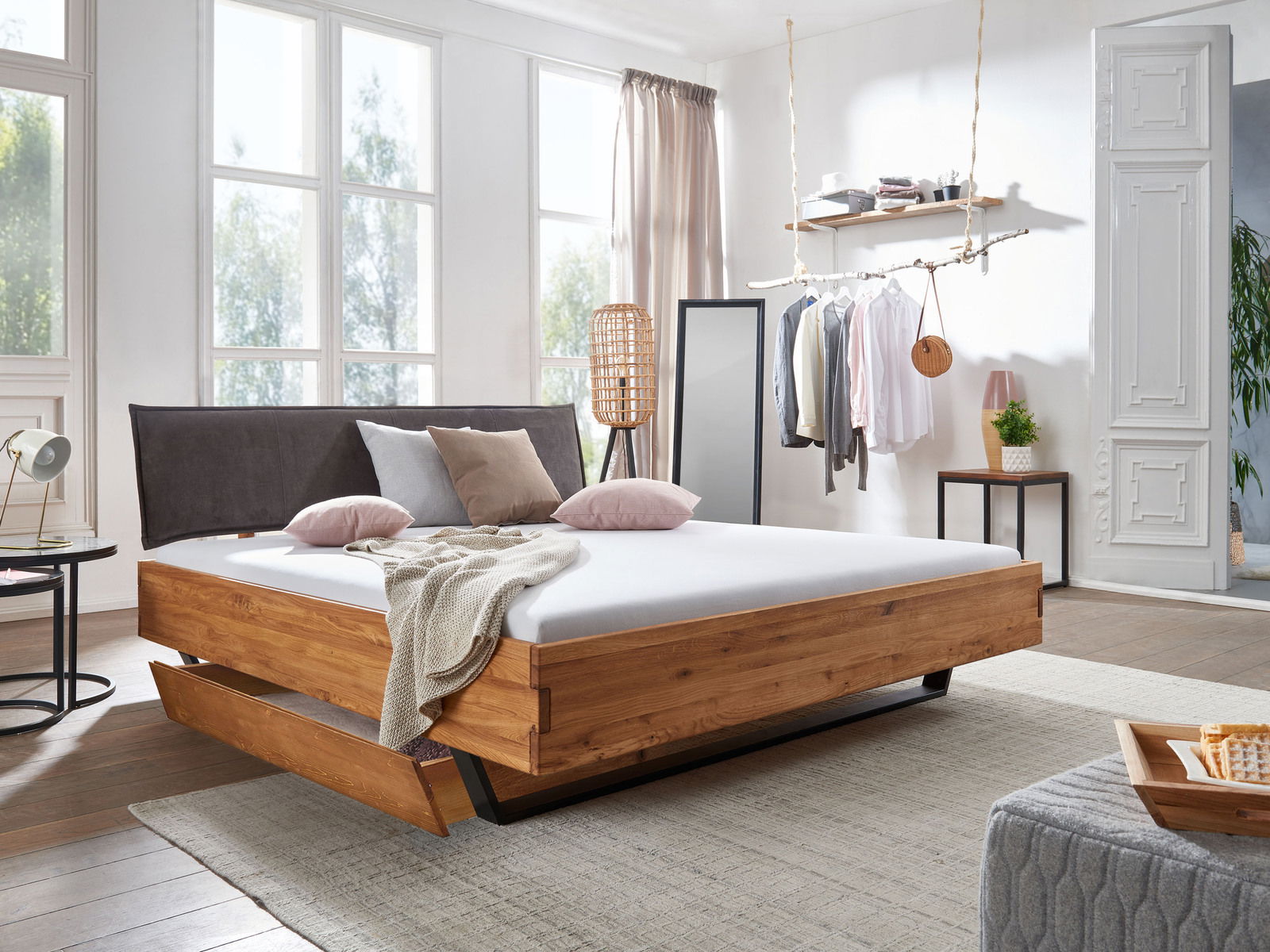 Holzbett mit Schubkasten in modernem Schlafzimmer, seitliche Perspektive