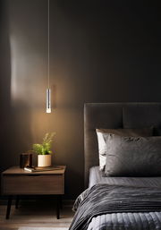 Moderne Akku-Pendelleuchte in einem stilvollen Schlafzimmer, seitliche Perspektive