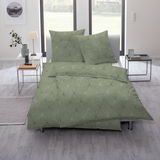 Grüne Bettwäsche mit geometrischem Muster auf einem Bett in einem modernen Schlafzimmer, seitliche Perspektive.