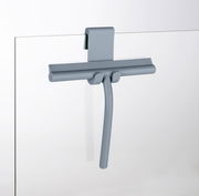 Grauer Badezimmerwischer aus Silikon, aufgehängt an einer Glaswand, seitliche Perspektive.