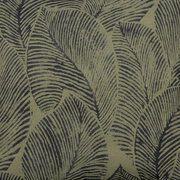 Nahaufnahme eines Stoffmusters mit großen, dunkelgrünen Blättern auf einem hellgrünen Hintergrund, perspektivisch von oben betrachtet.