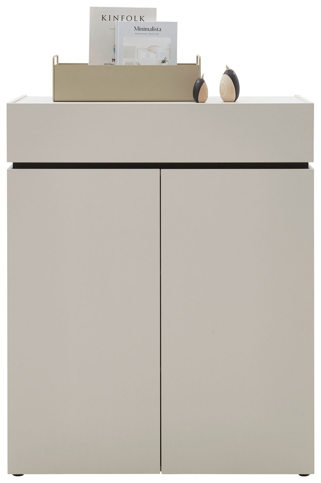 Frontale Ansicht einer modernen, minimalistischen Kommode in hellem Beige mit zwei Türen, dekoriert mit einem Tablett und Büchern auf der Oberseite.