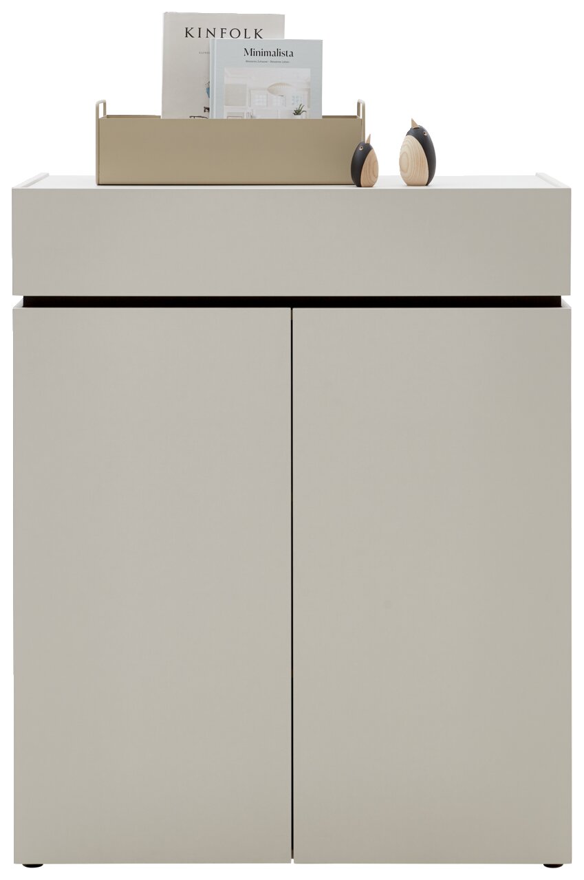 Frontale Ansicht einer modernen, minimalistischen Kommode in hellem Beige mit zwei Türen, dekoriert mit einem Tablett und Büchern auf der Oberseite.