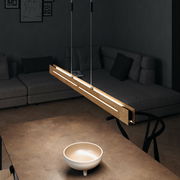 Moderne LED-Pendelleuchte aus Holz, von oben betrachtet, über einem Tisch in einem stilvollen Wohnzimmer hängend.