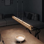 Moderne LED-Pendelleuchte aus Holz, von oben betrachtet, über einem Tisch in einem stilvollen Wohnzimmer hängend.