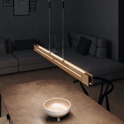 Moderne LED-Pendelleuchte aus Holz, von oben betrachtet, über einem Tisch in einem stilvollen Wohnzimmer hängend.