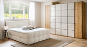 Gemütliches Boxbett in einem hellen Schlafzimmer mit großem Fenster, moderner Kleiderschrank und stilvolle Dekorationen, seitliche Perspektive.