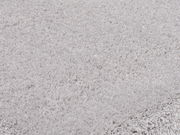 Nahaufnahme eines weichen, hellgrauen Teppichs mit flauschiger Textur.