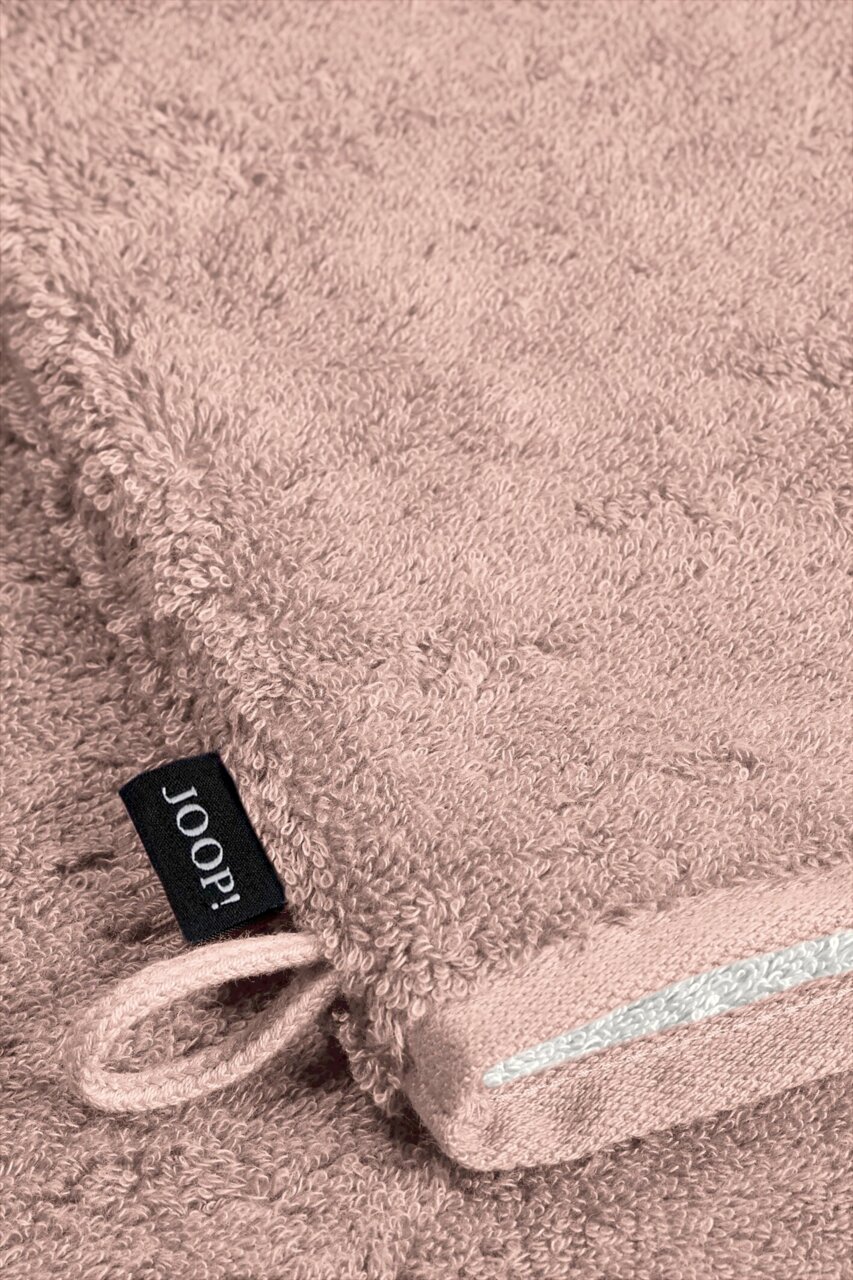 Nahaufnahme eines rosafarbenen Waschhandschuhs mit einer Schlaufe und einem schwarzen Etikett mit der Aufschrift 'JOOP!'