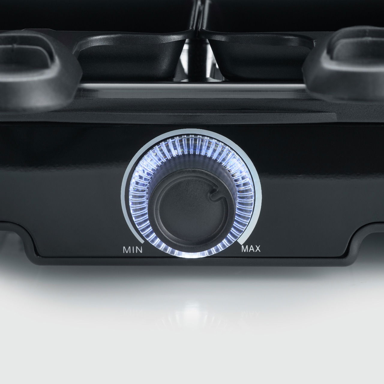 Nahaufnahme eines Raclette Grills mit beleuchtetem Temperaturregler, Ansicht von vorne.