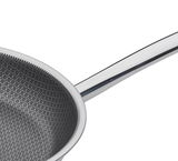 Nahaufnahme einer Bratpfanne mit hexagonalem Muster auf der Innenfläche und einem glänzenden Griff, von oben betrachtet.