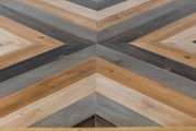 Nahaufnahme eines Couchtischs mit geometrischem Muster aus Holz in verschiedenen Brauntönen, von oben betrachtet.