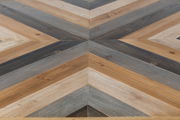 Nahaufnahme eines Couchtischs mit geometrischem Muster aus Holz in verschiedenen Brauntönen, von oben betrachtet.