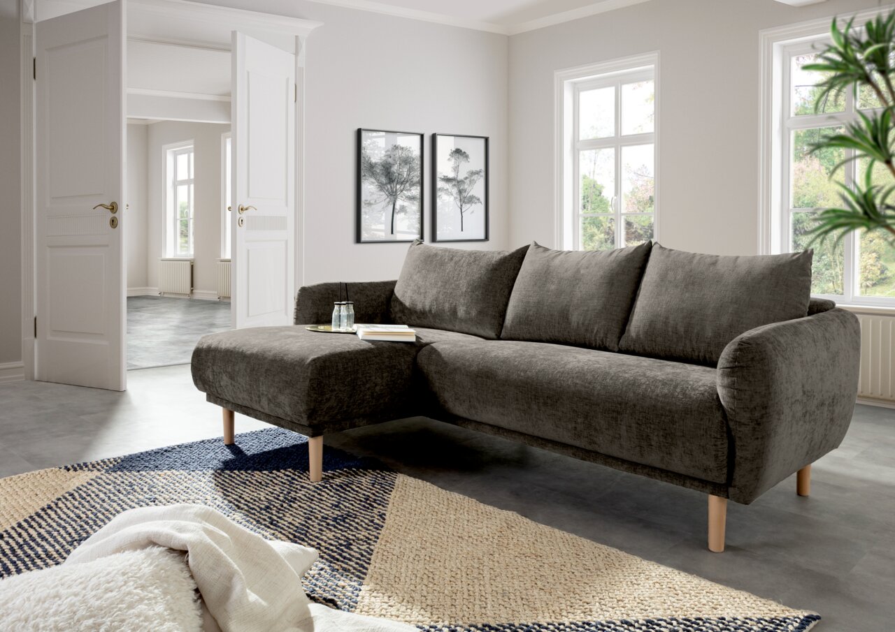 Graues Ecksofa mit Holzfüßen in einem modernen Wohnzimmer, Perspektive von vorne links.