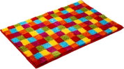 Bunter, flauschiger Badteppich mit quadratischem Patchwork-Muster in Rot, Gelb, Blau, Grün, Orange und Pink, in schräger Draufsicht (3/4-Perspektive) auf weißem Hintergrund