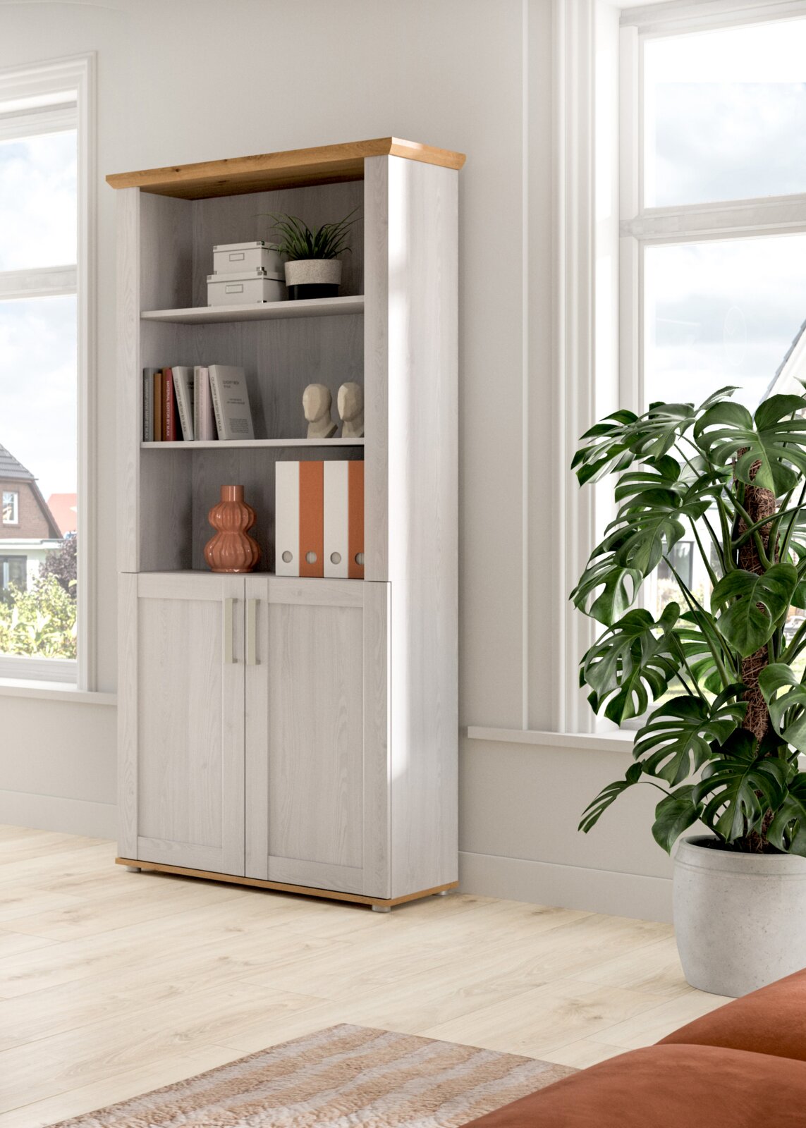 Hohes Regal mit weißer Holzoptik und naturfarbener Abdeckplatte, offenen Fächern und zwei Türen unten, dekoriert mit Büchern und Ordnern, im hellen Raum am Fenster; Perspektive: leicht schräg von vorn links