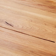 Nahaufnahme einer Holzoberfläche mit natürlicher Maserung, perspektivisch von oben betrachtet.