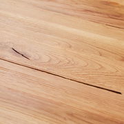 Nahaufnahme einer Holzoberfläche mit natürlicher Maserung, perspektivisch von oben betrachtet.