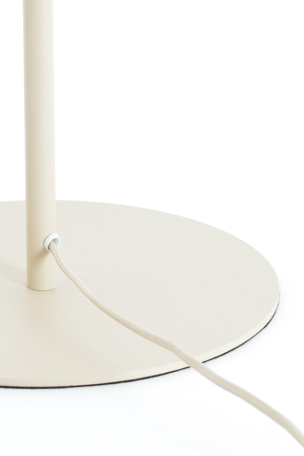 Close-up vanuit schuin vooraanzicht van de crèmekleurige ronde lampvoet met verticale standaard en met textiel omwikkeld snoer