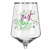 Weinglas mit der Aufschrift 'just relax' in lila und grün, verziert mit Limettenscheiben und Kräutern, aus der Frontalperspektive.