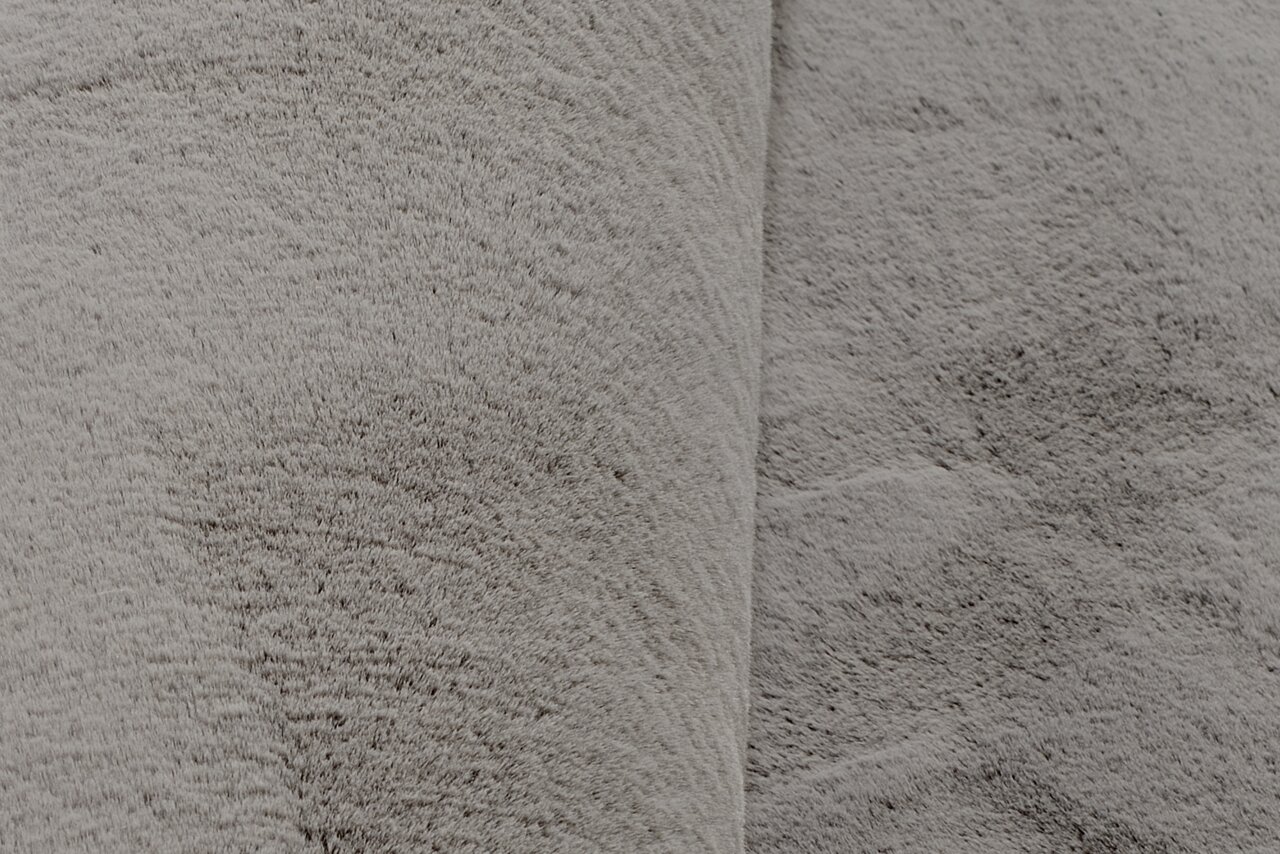 Nahaufnahme eines grauen Fellteppichs mit weicher Textur.