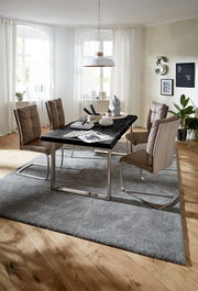 Moderne Esszimmeransicht mit einer eleganten Tischplatte in 180x90 cm, umgeben von stilvollen Stühlen und dekorativen Elementen, aus der Perspektive eines hellen, einladenden Raumes.