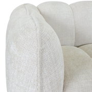 Nahaufnahme eines cremefarbenen Big-Sofas mit strukturierter Oberfläche, seitliche Perspektive.