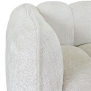 Nahaufnahme eines cremefarbenen Big-Sofas mit strukturierter Oberfläche, seitliche Perspektive.