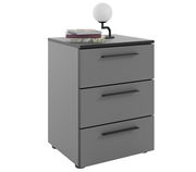 Graue Nachtkommode mit drei Schubladen, darauf eine Lampe und Bücher, Perspektive von vorne links