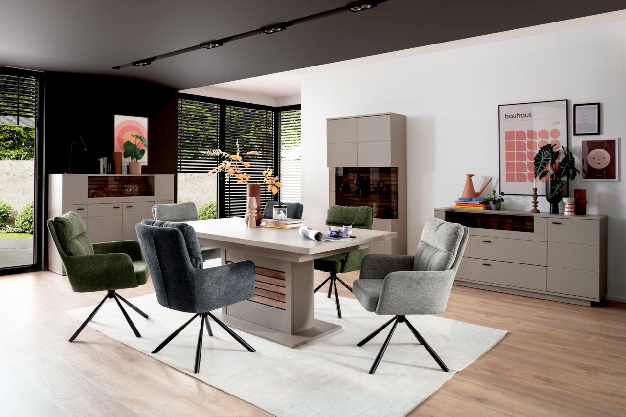 Moderne eethoek met eettafel en gestoffeerde stoelen in een lichte ruimte, zijaanzicht.