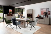 Moderne eethoek met eettafel en gestoffeerde stoelen in een lichte ruimte, zijaanzicht.