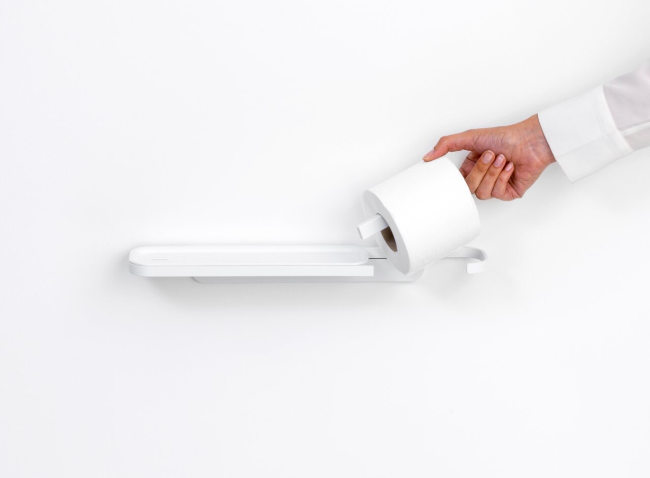 Moderner Toilettenpapierhalter mit Ablage, seitliche Perspektive, Hand legt Toilettenpapierrolle ein.