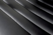 Nahaufnahme der schwarzen, gesteppten Lederoberfläche eines Schwingstuhls, von oben betrachtet.