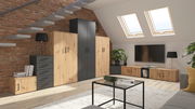 Moderne Wohnzimmermöbel in einem Dachgeschoss mit Ziegelwand, bestehend aus einer Kombination von Holz- und dunklen Elementen, inklusive Kommoden, Schränken und einem TV-Board. Perspektive von der Seite mit Blick auf die gesamte Möbelanordnung.