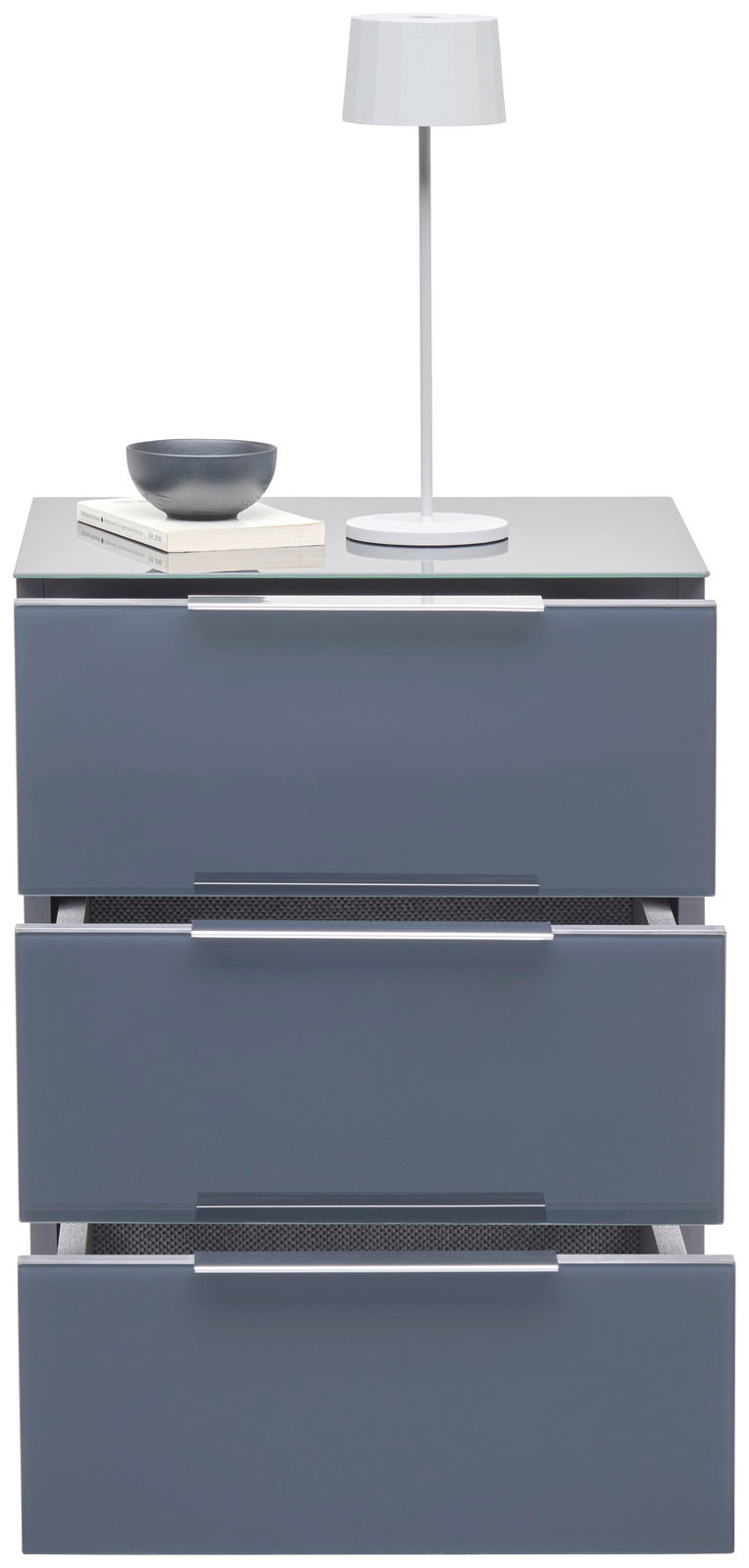 Moderne Nachtkonsole mit drei Schubladen in grauer Hochglanzoptik, darauf eine weiße Tischlampe und eine Schale, Frontalansicht