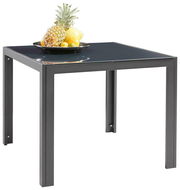 Moderner quadratischer Gartentisch mit schwarzer Glasplatte, darauf ein Obstteller mit Ananas und Zitronen, seitliche Perspektive.