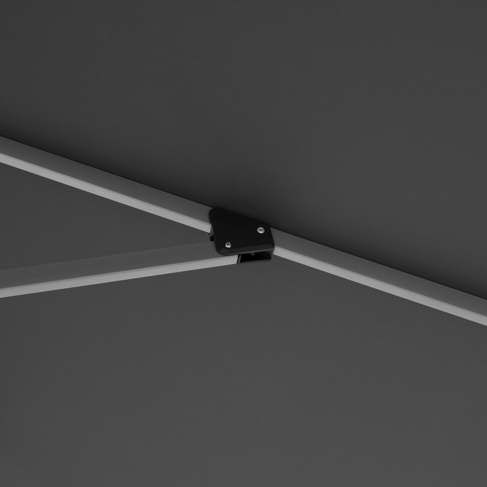 Detailaufnahme von unten auf die Streben- und Gelenkverbindung eines grauen Sonnenschirms mit Metallgestänge und schwarzem Verbinder
