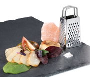 Mini-Vierkantreibe aus Edelstahl auf einer Schieferplatte, umgeben von frischen Zutaten, aus seitlicher Perspektive.