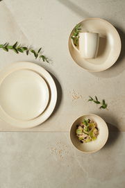 Vogelperspektive auf ein 20-teiliges Kombiservice-Set 'Cafe del' in neutralen Tönen mit Teller, Tasse und Schale, dekoriert mit grünen Blättern.
