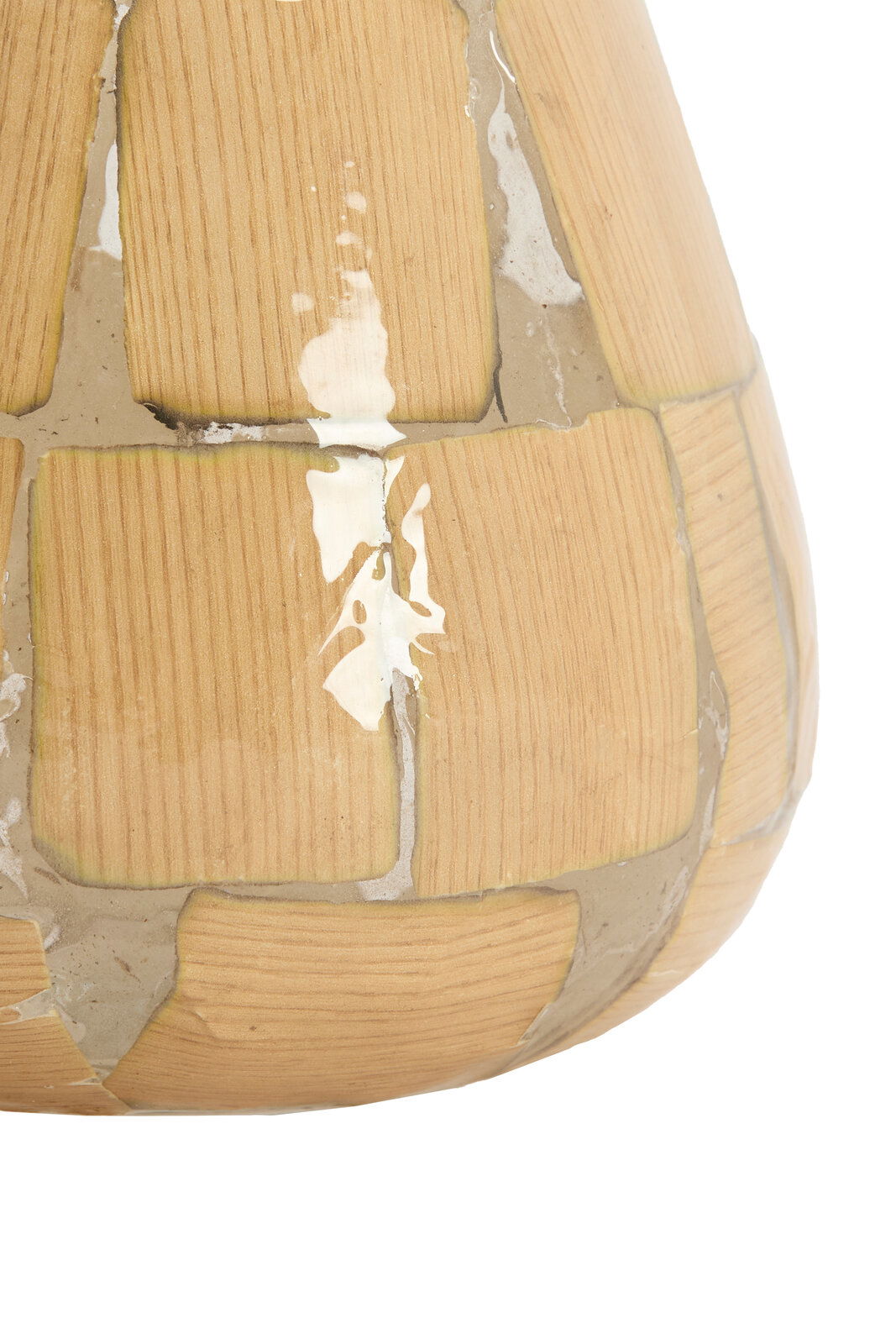 Nahaufnahme eines Teelichts mit holzähnlicher Struktur und glänzender Oberfläche, seitliche Perspektive.