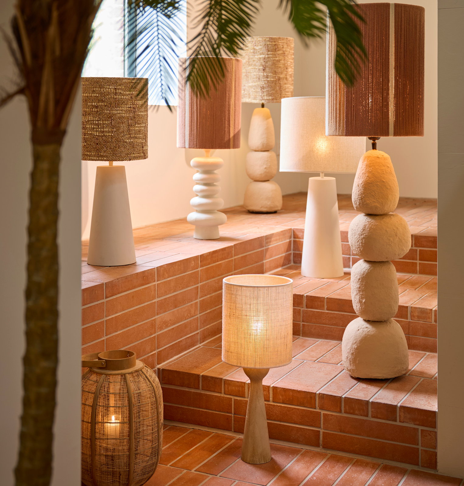 Light&Living Lampenfuß FESTINA Eine Sammlung von dekorativen Lampen auf einer Treppe mit Terrakottafliesen, darunter ein Lampenfuß mit natürlicher Holzoptik. Die Perspektive zeigt die Lampen von der Seite.