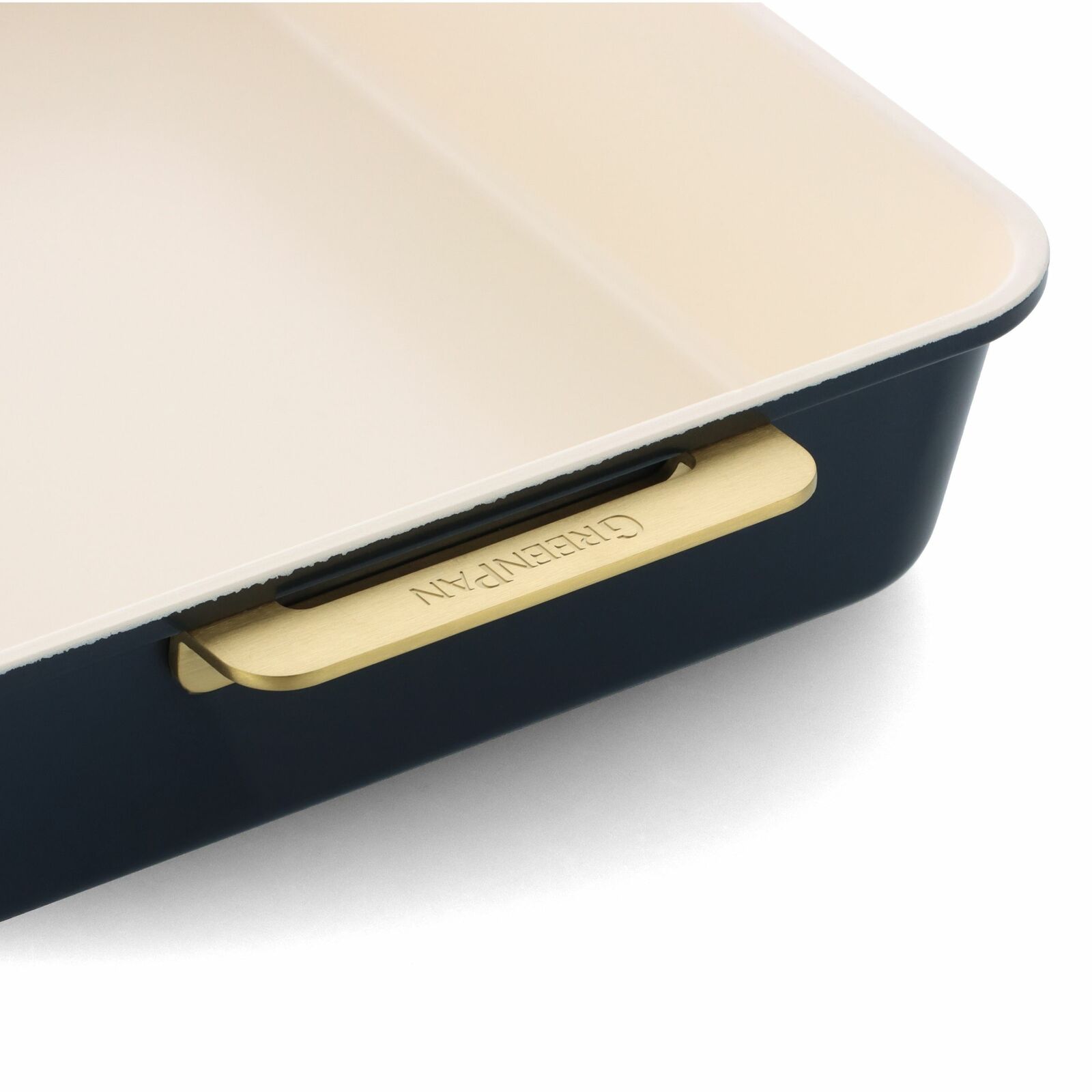 Nahaufnahme einer eckigen Backform mit cremefarbener Innenbeschichtung und dunkelblauer Außenseite, seitliche Perspektive mit sichtbarem Griff.