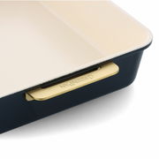 Nahaufnahme einer eckigen Backform mit cremefarbener Innenbeschichtung und dunkelblauer Außenseite, seitliche Perspektive mit sichtbarem Griff.