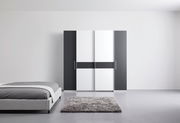 Moderner Dreh- und Schwebetürenschrank mit vier Türen in Schwarz-Weiß-Design, frontal abgebildet in einem minimalistischen Schlafzimmer.