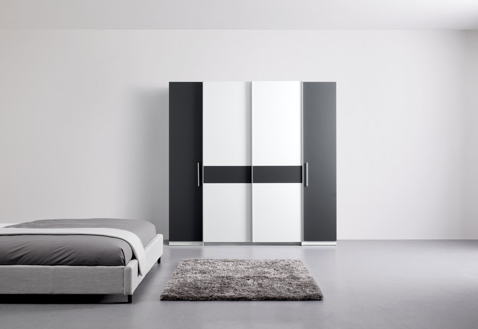 Moderner Dreh- und Schwebetürenschrank mit vier Türen in Schwarz-Weiß-Design, frontal abgebildet in einem minimalistischen Schlafzimmer.